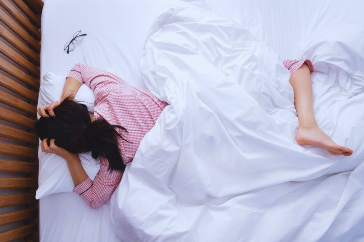 Donna che si rigira nel letto senza riuscire a dormire