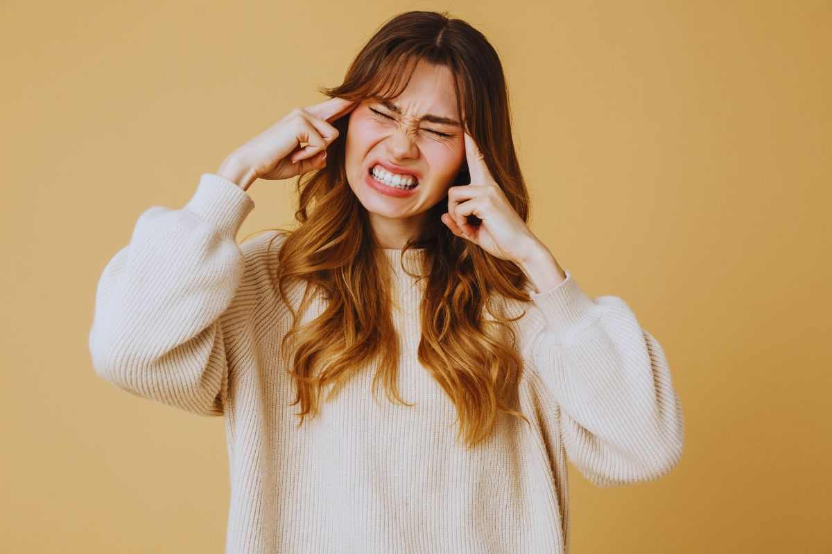 Ragazza che si tappa le orecchie a causa di un rumore fastidioso