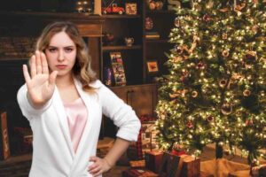 Albero di Natale in casa, donna che fa stop con la mano