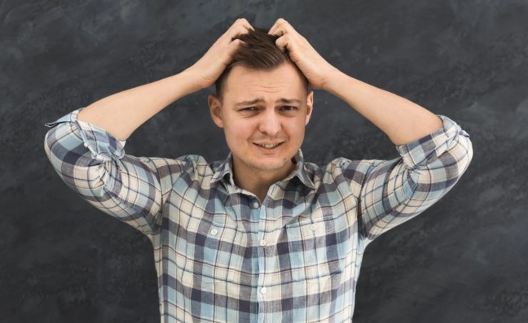 uomo disperato con le mani nei capelli